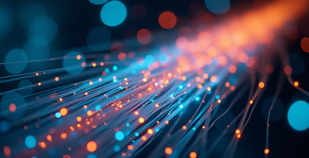 Vue macro de fibres optiques colorées transmettant des données lumineuses, symbolisant l'analyse des signaux faibles.